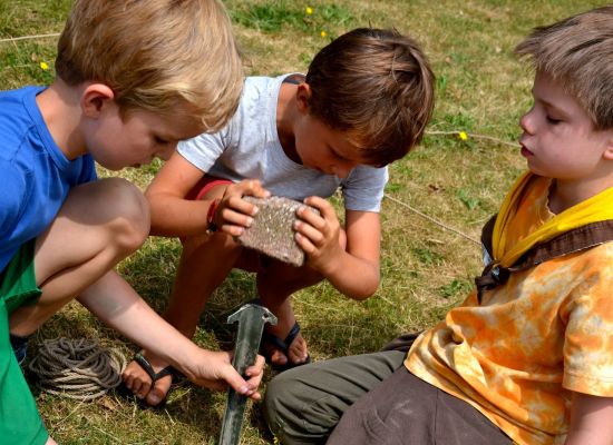 Jonge scouts helpen elkaar bij het opzetten van een tent