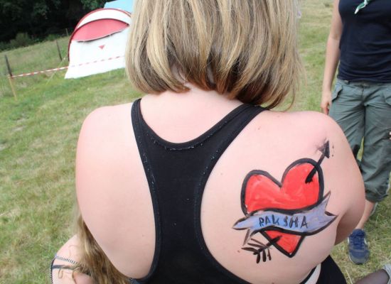 een meisje met een geschilderd hartje op haar rug
