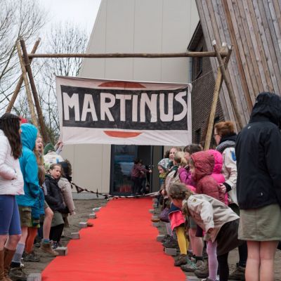 Silas De Munck Gidsen staan aan beide zijden van een rode loper. De loper leidt naar de inkom van het nieuwe lokaal.