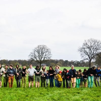 lange rij ouders en scouts staan arm in arm naast elkaar