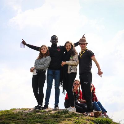 4 jongeren poseren op de top van een heuvel