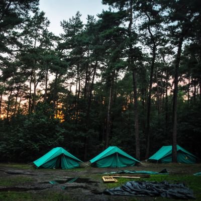 3 patrouilletenten onder de bomen bij zonsondergang
