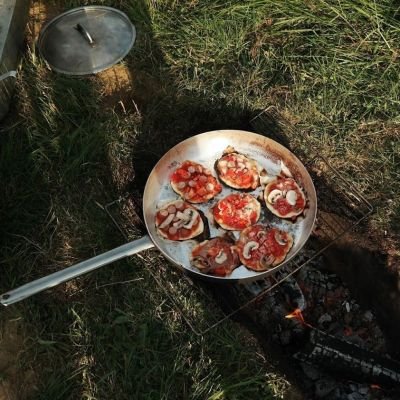 Pan met lekkere zelfgemaakte mini pizzaatjes op houtvuur.