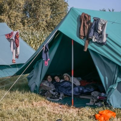 tent met 3 scoutsmeisjes, boven de tent hangen kleren te drogen