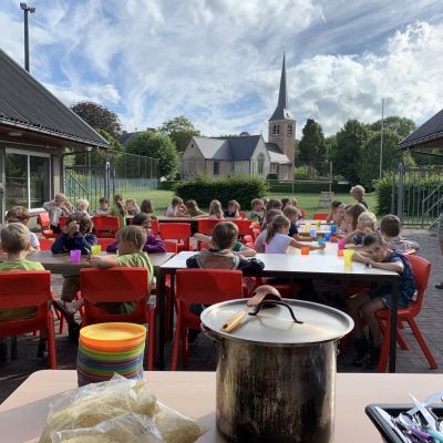 Leden aan tafel op hun zomerkamp