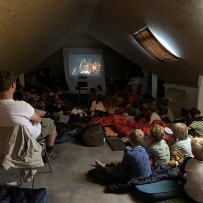Kapoenen kijken een film in een verduisterd lokaal.