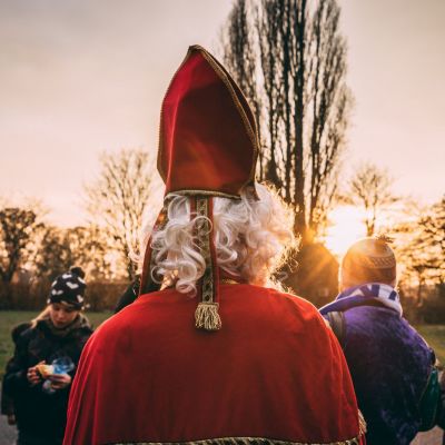 Sonterklaas en Zwarte piet op bezoek bij een groepje snoepende leden.