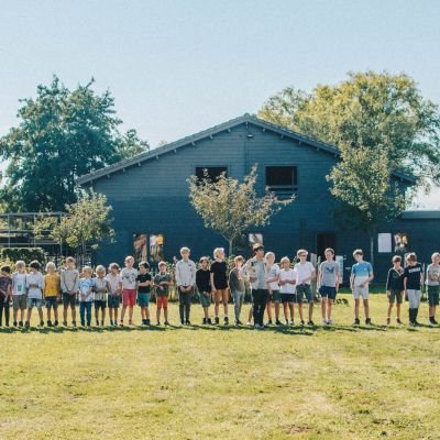 Groep leden staat op een lijn voor hun lokaal in latem