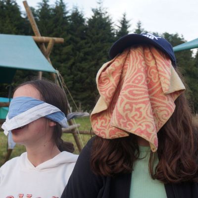Twee geblinddoekte gidsen op kamp