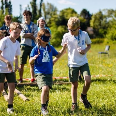 Fotograaf: Sander Petré twee welpen begeleiden een geblinddoekte welp