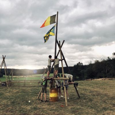 Arthur Snoeck twee jongens staan op een driepikkel en plaatsen er een vlaggenmast op