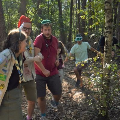 Scoutsleden doen een spel in het bos