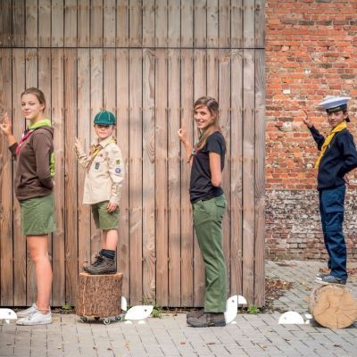verschillende scoutsuniformen op een rij
