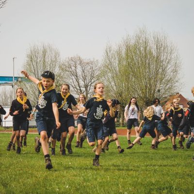 een groep zeewelpen lopen over hun scoutsterrein