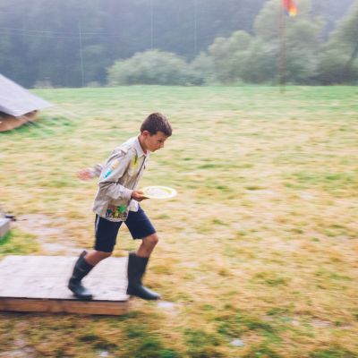 Jonggiver die door de regen naar de tent loopt