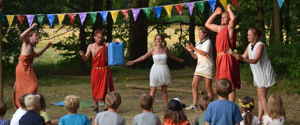 Kapoenen die toekijken terwijl de leiding in Romeinse kleren danst.