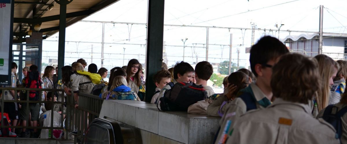 groep scouts wacht op de trein