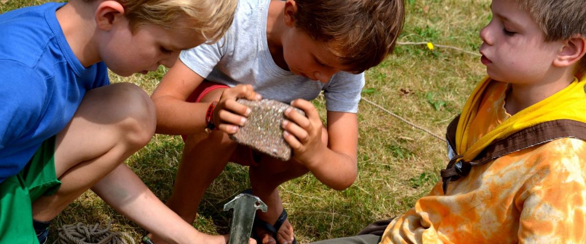 Jonge scouts helpen elkaar bij het opzetten van een tent Jonge scouts helpen elkaar bij het opzetten van een tent