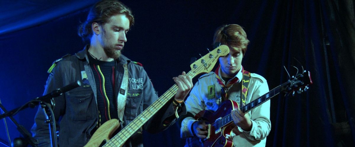 Twee scoutsmuzikanten met gitaar en bas op een podium