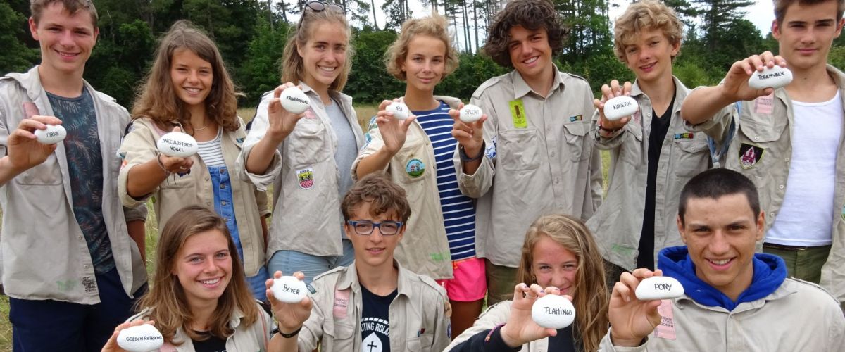 een groep givers die elk een steen vasthouden waar hun voortotem opstaat