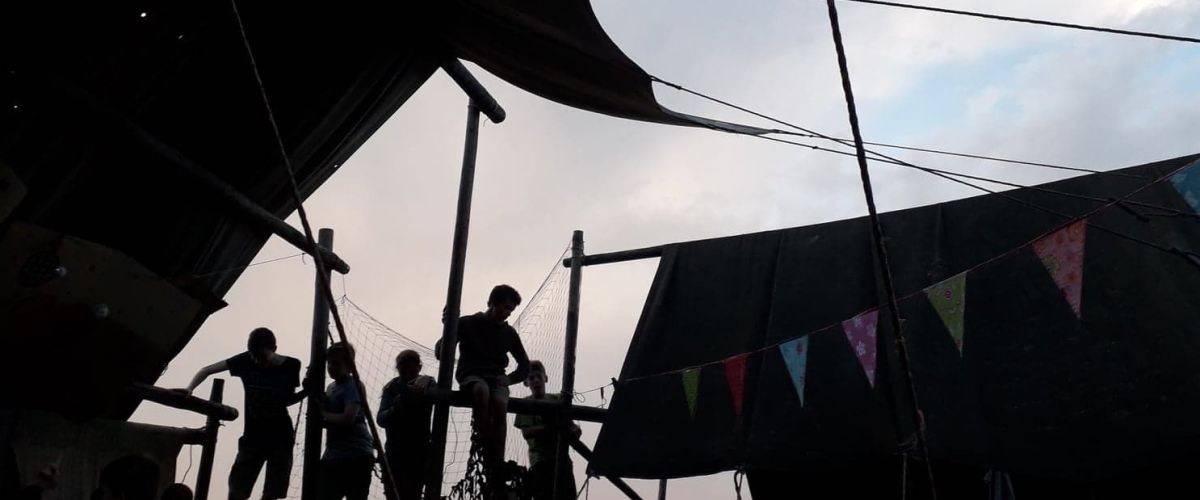 Kinderen die in de hoogte zitten, waar hun tenten staan en het versierd is met vlaggetjes