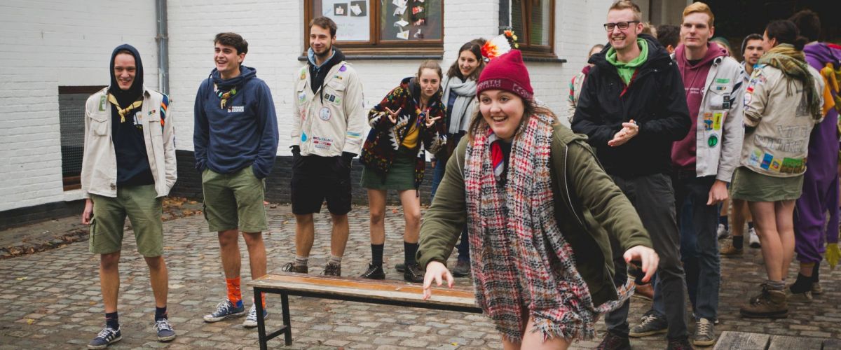 Scoutsleiding staan in twee groepjes op de binnenplaats van De Kluis. Klaar voor een spel. Van een groep begint iemand te lopen.