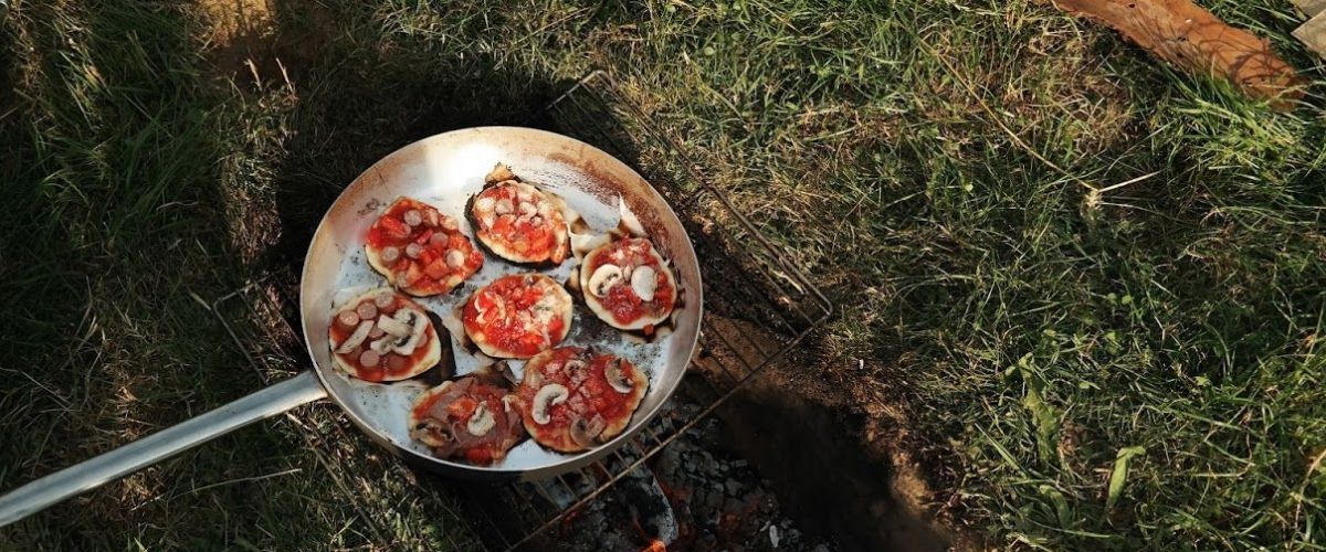 Pan met lekkere zelfgemaakte mini pizzaatjes op houtvuur.