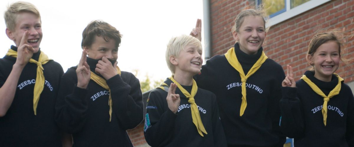 Toon Janssen Vijf zeescouts, in patrouille, doen de scoutsgroet