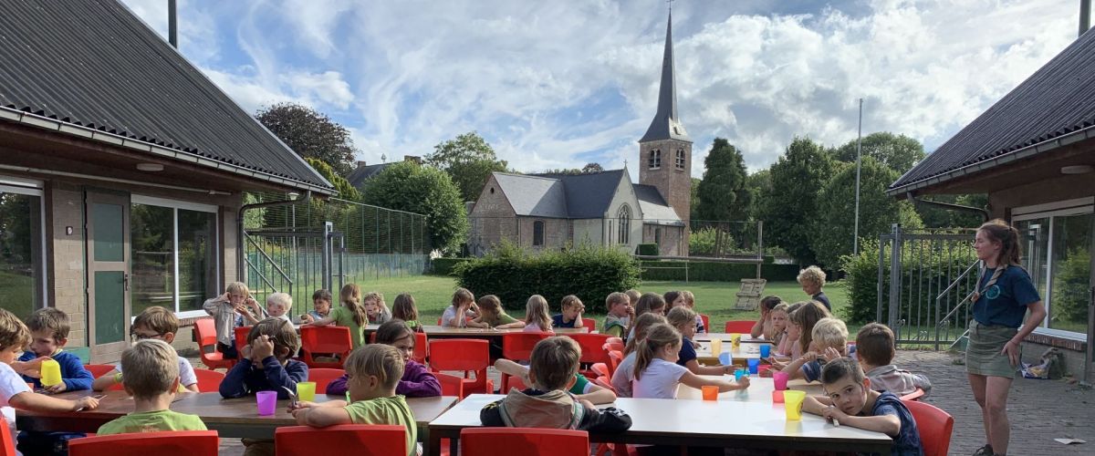 fotograaf: Hannelore Huyghe Leden aan tafel op hun zomerkamp