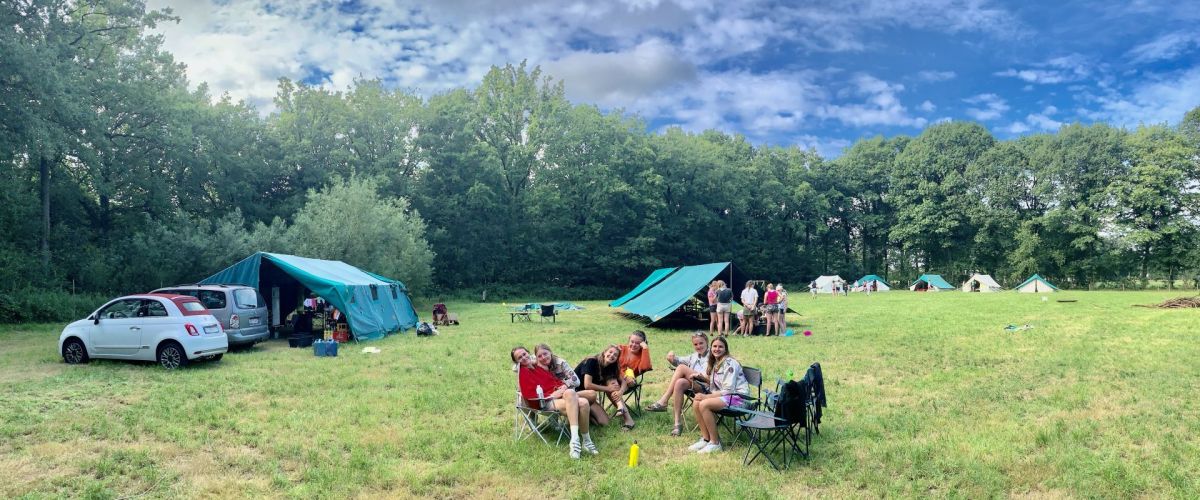 Kampterrein met op de voorgrond een groepje leiding