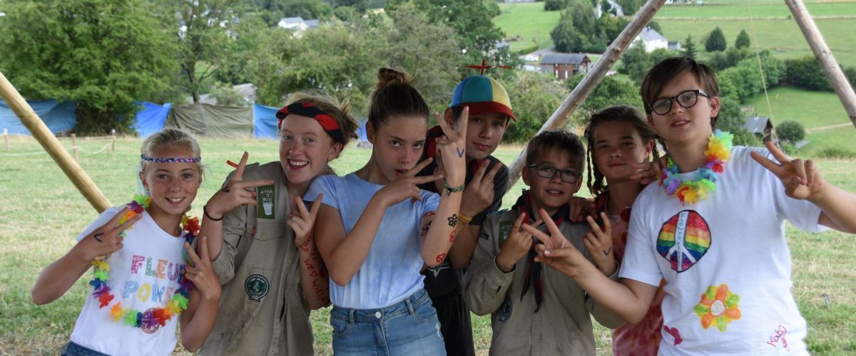 Een groepje jonggivers op kamp verkleed als hippies