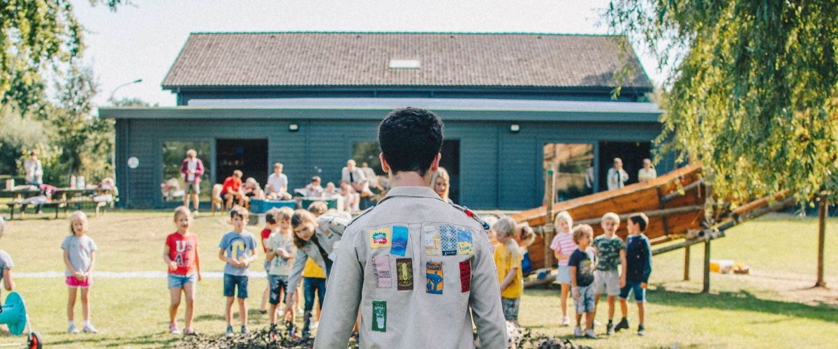 fotograaf: Sander Van Damme Leider staat voor een groep leden op het scoutsterrein