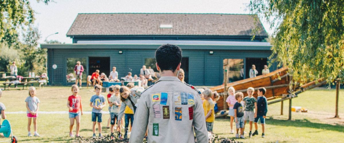 Leider staat voor een groep leden op het scoutsterrein