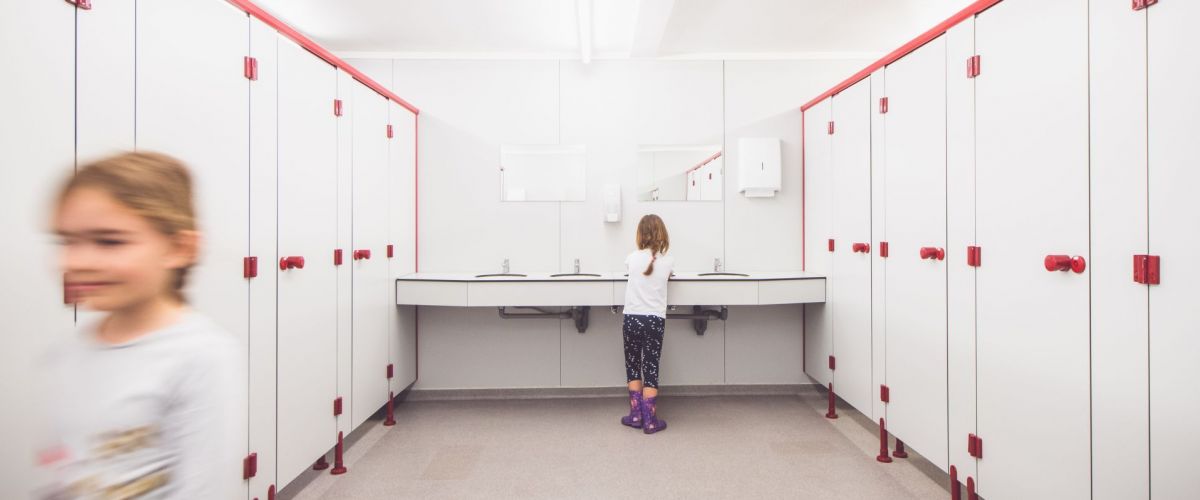 Dries Luyten een meisje wast haar handen in een wc, een ander meisje loopt wazig uit beeld.