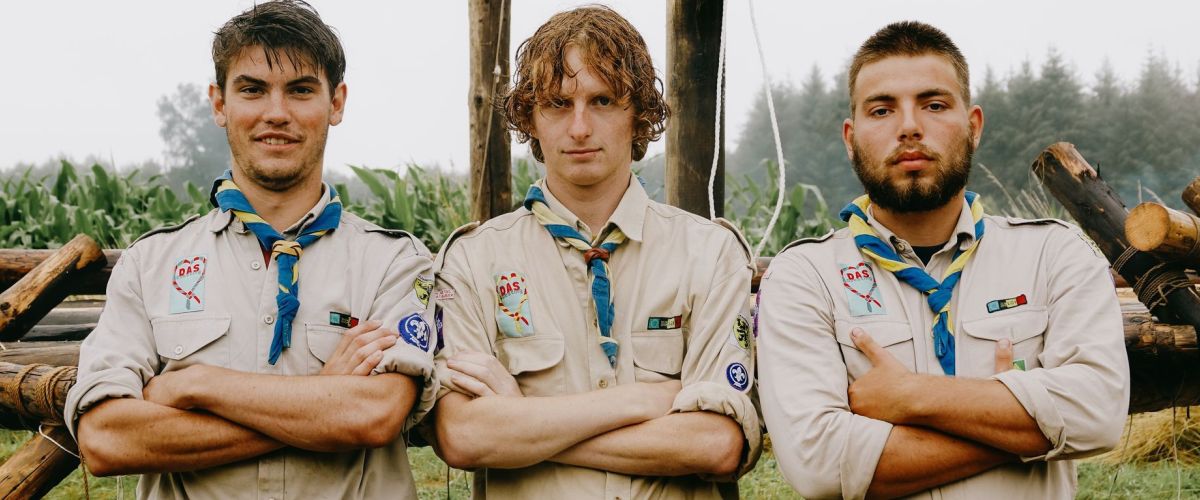 Fotograaf: Jari Sijbers drie scoutsleiders staan op een rijtje, armen over elkaar, op kamp