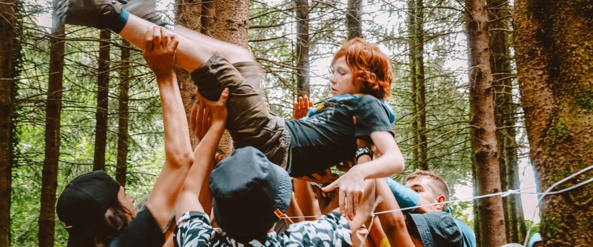 fotograaf: Jari Sijbers Een groep leiders draagt een jonggiver op hun handen