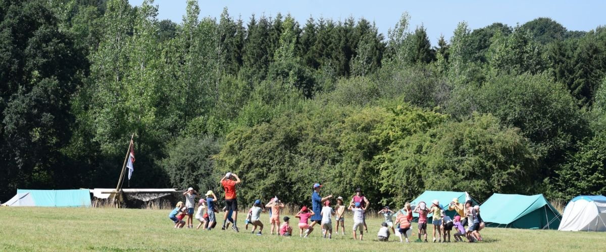 Groep leden zitten in een rking op hun kampterrein