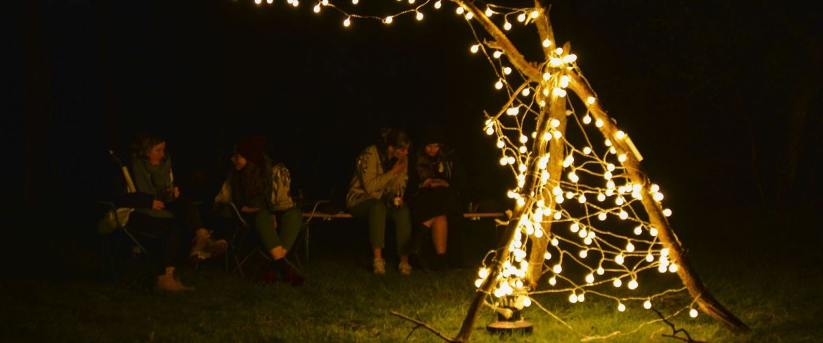 Structuurvrijwilligers rond een "kampvuur" van lichtjes