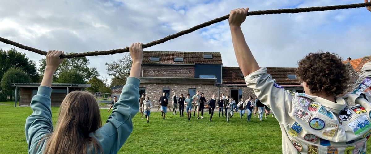 Twee scouts houden een touw in de lucht