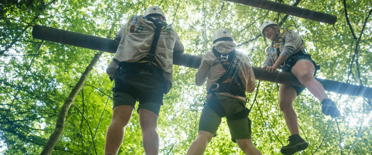 Drie leiders klimmen in het touwenparcour.