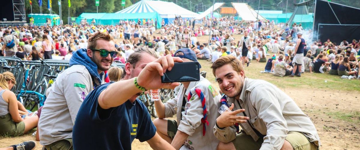 Leiders nemen een selfie, op de achtergrond is herfstontmoeting aan de gang.