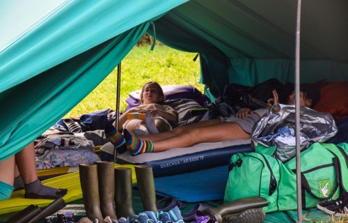 Gidsen liggen op hun veldbed in de tent