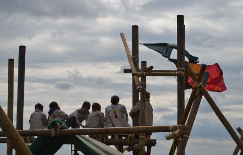 Leden zitten op een gesjorde constructie op zomerkamp
