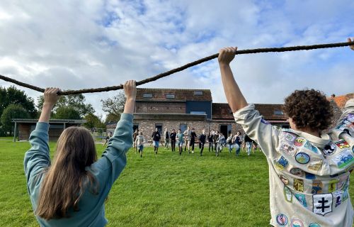 Twee scouts houden een touw in de lucht