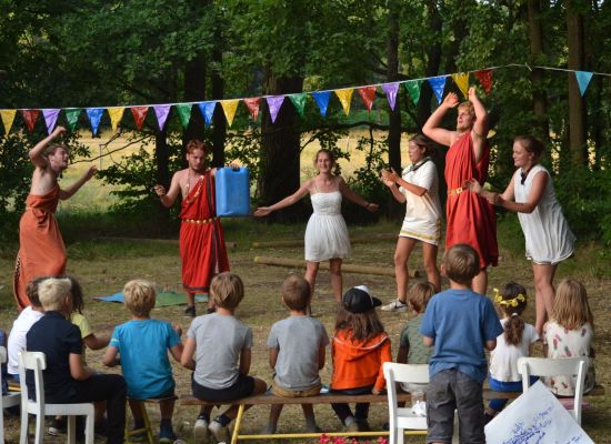 Kapoenen die toekijken terwijl de leiding in Romeinse kleren danst.