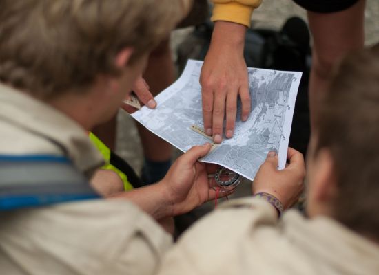 scouts zoeken de weg op de stafkaart