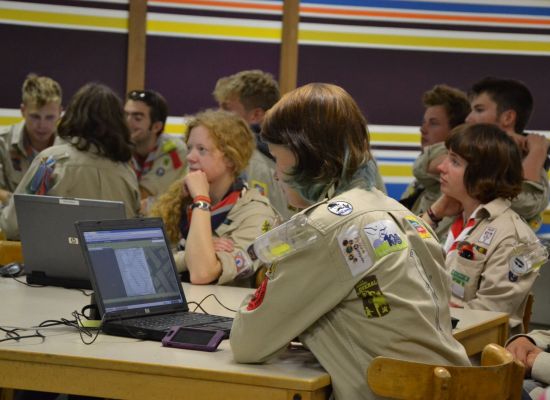 leiding in uniform in een lokaal allemaal over laptops gebogen