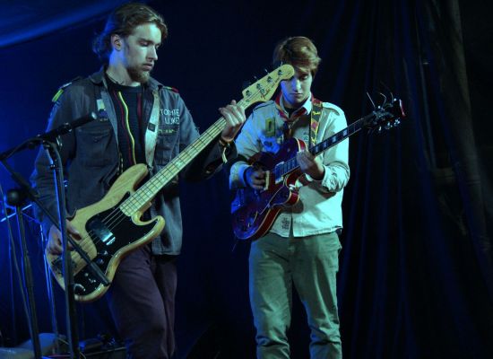 Twee scoutsmuzikanten met gitaar en bas op een podium