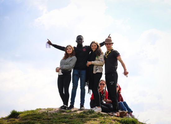 4 jongeren poseren op de top van een heuvel