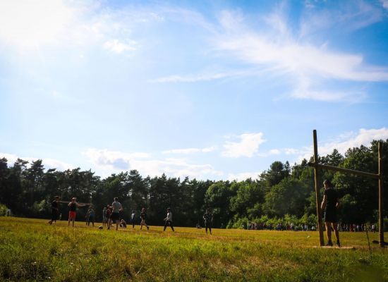 Groepje jongeren aan het voetballen op een veld met gesjorde goals.